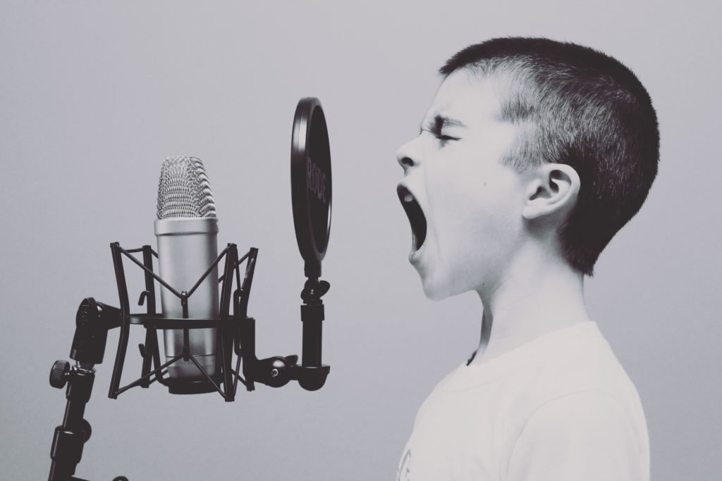 boy screaming into a voice over microphone