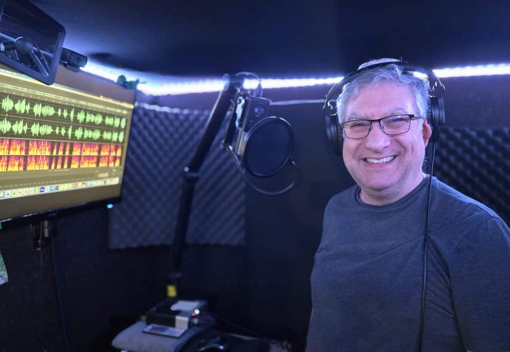 David Gilbert pictured smiling in his recording booth